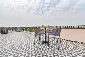 a patio with chairs and a table on a roof at FabHotel Blooming Beds Pearl in Jaipur