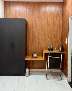 a desk with a chair next to a wooden wall at The RB's Farm in Fīrozābād