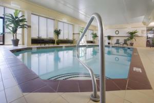 a large swimming pool with a handrail in a hotel lobby at Embassy Suites Charleston in Charleston