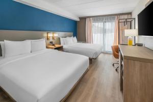 a hotel room with two beds and a desk at Comfort Inn Belleville in Belleville
