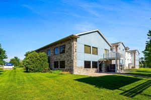 a large brick building on a grass field at Comfort Inn & Suites Weston - Wausau in Weston