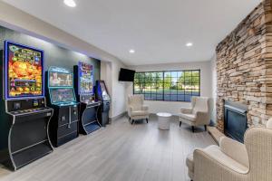 a gaming room with two arcade machines and chairs at Comfort Inn & Suites Weston - Wausau in Weston