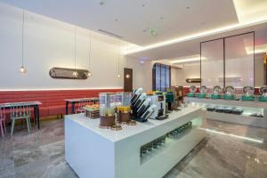 a restaurant with a counter with aasteryasteryasteryasteryasteryasteryasteryasteryastery at Ibis Styles Nantong North High-tech Zone in Nantong