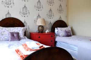 a bedroom with two beds and a red dresser at Bove Town House Apartments in Glastonbury