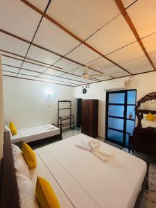 a room with two beds with yellow pillows at Monaco Guest House in Devinuwara +40 photos