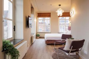 a hotel room with a bed and two chairs at Boutique Hotel Jeroen in Den Bosch