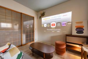 a living room with a table and a screen at Cozy Retreat LATTE in Yatomi 