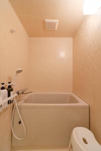 a bathroom with a bath tub and a toilet at Cozy Retreat LATTE in Yatomi  +39 photos
