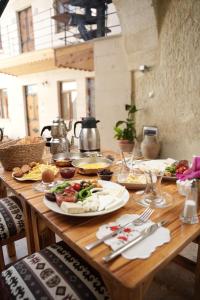 a wooden table with plates of food on it at Colina Stone House in Mustafakemalpaşa