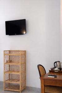 a room with a desk and a television on a wall at The Jungle Pearl Hotel in Udawalawe