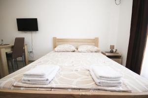 a bedroom with a bed with towels on it at Apartments KA-7 in Podgorica