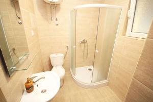 a bathroom with a shower and a toilet and a sink at Apartments KA-7 in Podgorica
