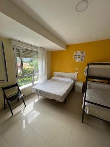 a bedroom with a bed and a chair and a window at Albergue Internacional de Llanes in Llanes