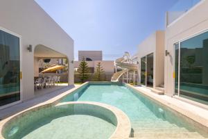 a swimming pool in the middle of a house at Luma & Malta PoolVilla Cha-am in Sathani Nong Ta Phot