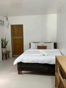 a bedroom with a large bed with white sheets at Ayu Homestay in San Isidro