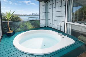 a bath tub in a bathroom with a large window at Ascot On Fenton in Rotorua +27 photos