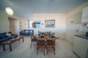 a living room with a table and chairs and a couch at The Blue Mile w Jacuzzi in Paralimni