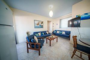 a living room with a blue couch and a table at The Blue Mile w Jacuzzi in Paralimni +9 photos