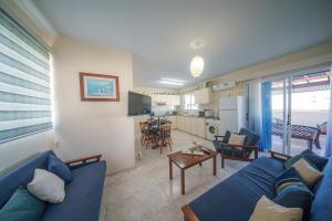 a living room with a blue couch and a kitchen at The Blue Mile w Jacuzzi in Paralimni