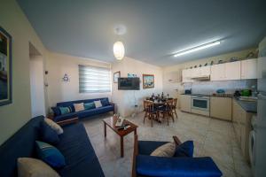 a living room with a blue couch and a table at The Blue Mile w Jacuzzi in Paralimni