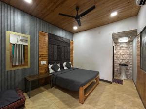 a bedroom with a bed and a ceiling fan at Wantara resort in Diveagar