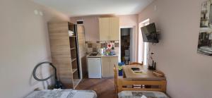 a small kitchen with a table and a kitchen with a refrigerator at Apartments Bellavista in Luštica
