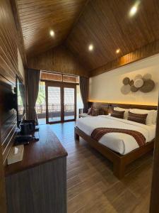a bedroom with a bed and a television in a room at Phi Phi Villa Resort in Phi Phi Islands +89 photos