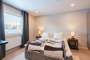 a bedroom with a bed and a large window at Lapland Lakeside Villa in Ranua