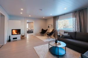a living room with a couch and a fireplace at Lapland Lakeside Villa in Ranua