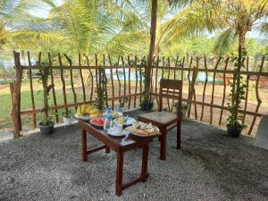 a table with food on it next to a wooden fence at water lily heaven in Tangalle