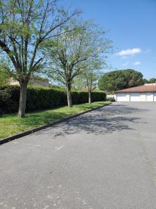 an empty street with trees and a building at APPT Cosy entier in Toulouse