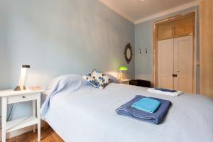 リスボンにあるArroios 100のベッドルーム1室(白いベッド1台、青いタオル付)