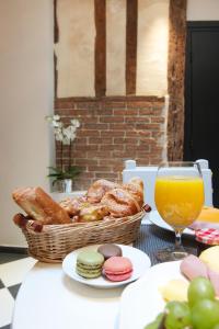 a table with a basket of pastries and a glass of orange juice at Hôtel le Clos de Notre Dame in Paris