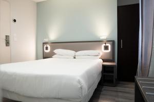 a bedroom with a large white bed with pillows at Aero Hotel in Issy-les-Moulineaux +17 photos