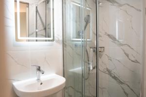 a bathroom with a sink and a glass shower at Aero Hotel in Issy-les-Moulineaux
