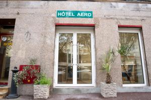 a hotel area with potted plants in front of a building at Aero Hotel in Issy-les-Moulineaux
