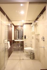 a bathroom with a shower and a toilet and a sink at Comfort Inn Sapphire - A Inde Hotel in Jaipur
