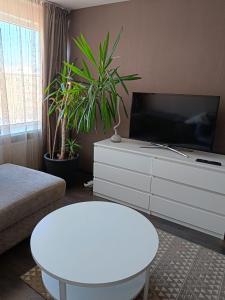 a living room with a tv and a white table at Cietokšņa 64 in Daugavpils
