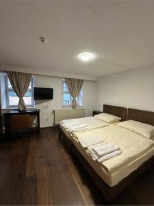 a bedroom with two beds and a flat screen tv at Gästehaus Anker in Dinkelsbühl