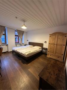 a bedroom with a large bed and a wooden cabinet at Gästehaus Anker in Dinkelsbühl
