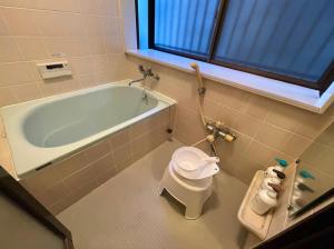 a bathroom with a bath tub and a toilet at Comfort Villa Takahata in Takahate +36 photos