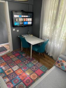 a table and two chairs and a tv in a room at Small House in İzmir