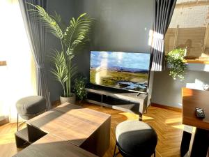 a living room with a flat screen tv and a table at Comfort Villa Takahata in Takahate