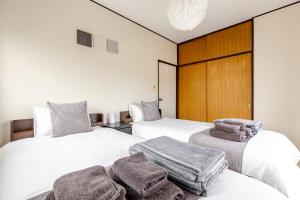 two beds in a hotel room with towels on them at Comfort Villa Takahata in Takahate