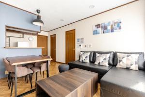a living room with a couch and a table at Comfort Villa Takahata in Takahate