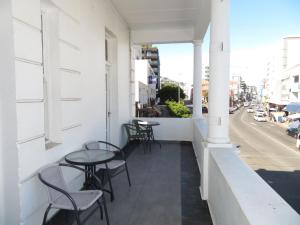 a balcony with tables and chairs and a street at CapePod Sea Point in Cape Town