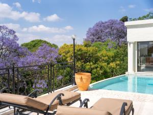 a patio with chairs and a swimming pool at Oniro Guest House in Bedfordview