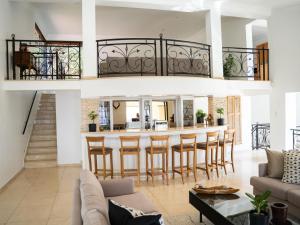 a kitchen and living room with a bar with stools at Oniro Guest House in Bedfordview