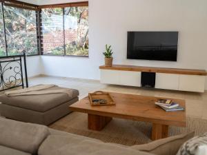 a living room with a television and a coffee table at Oniro Guest House in Bedfordview