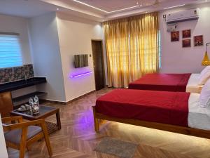 a hotel room with two beds and a television at Gokarna City Guest House in Gokarna